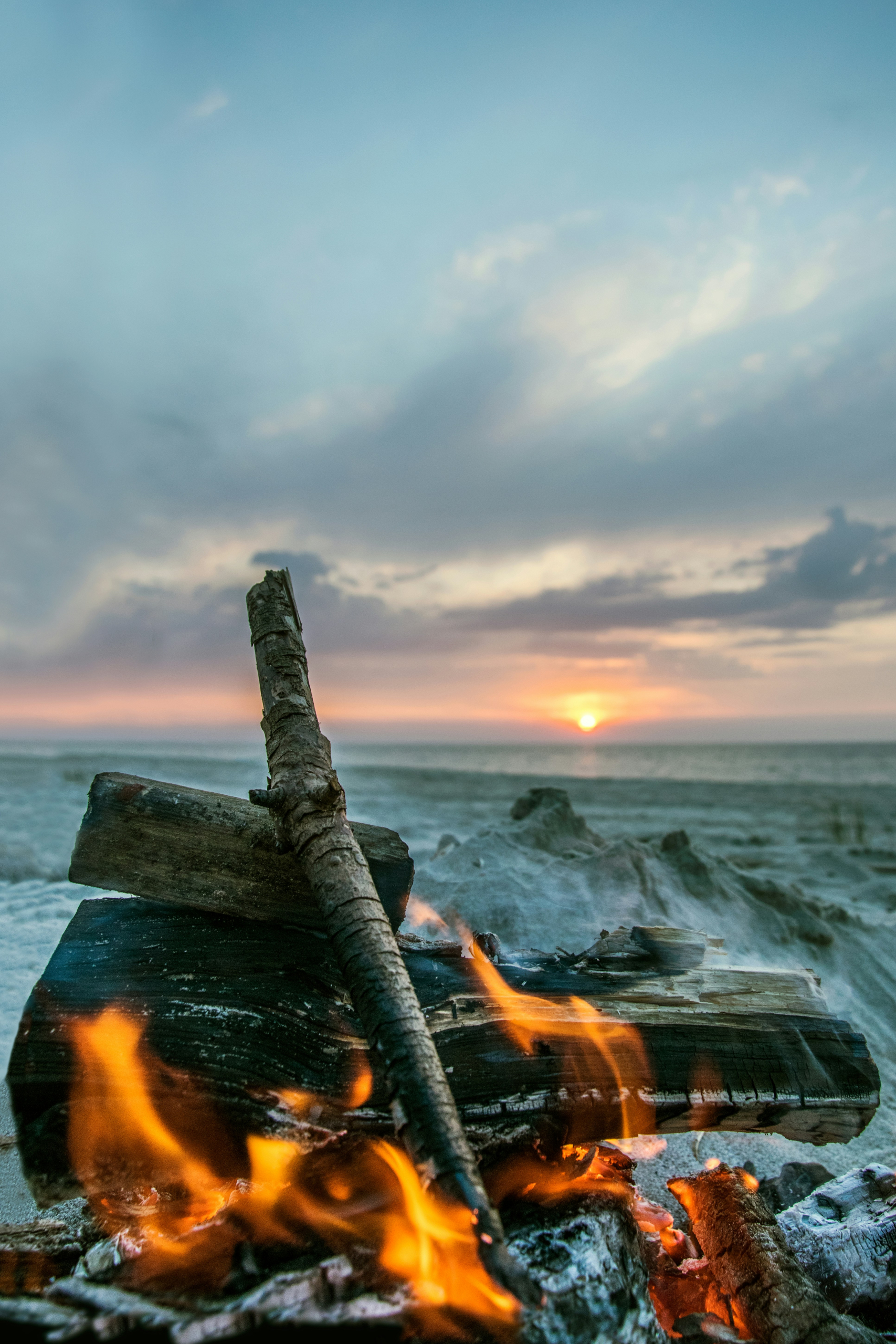 Bonfire on a beach at sunrise.